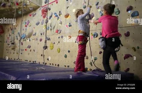 2 girls pulling a rope|Two girls pulling a safety rope next to the climbing wall Stock Video